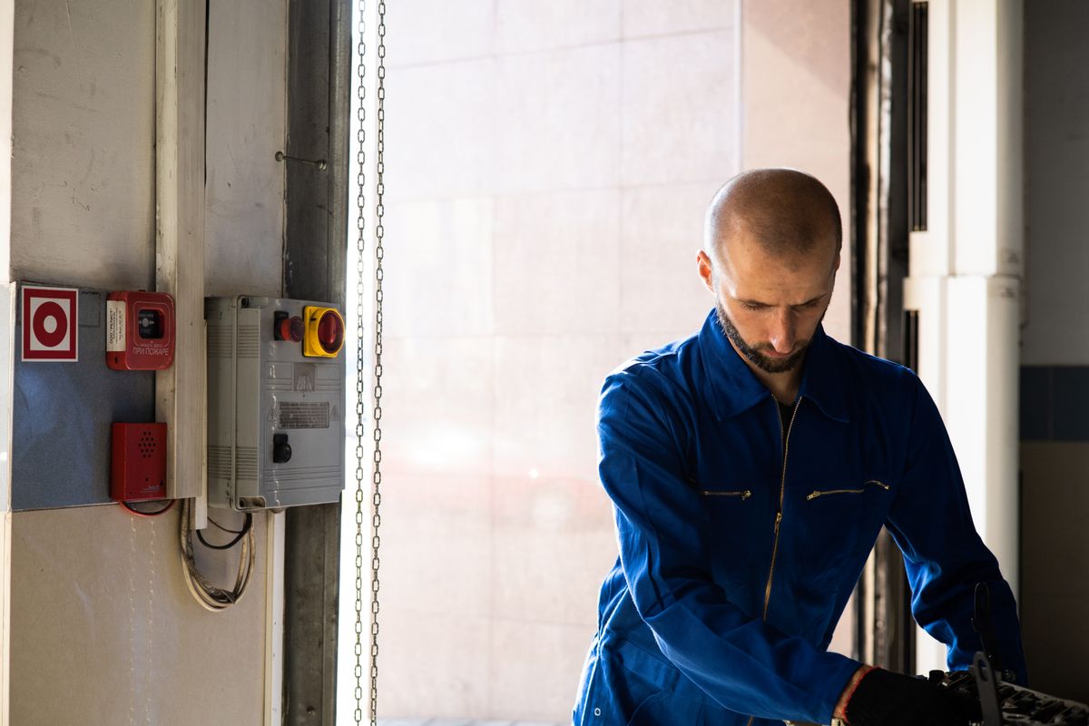 Un technicien en combinaison bleue au départ d'une intervention, sur un quai.